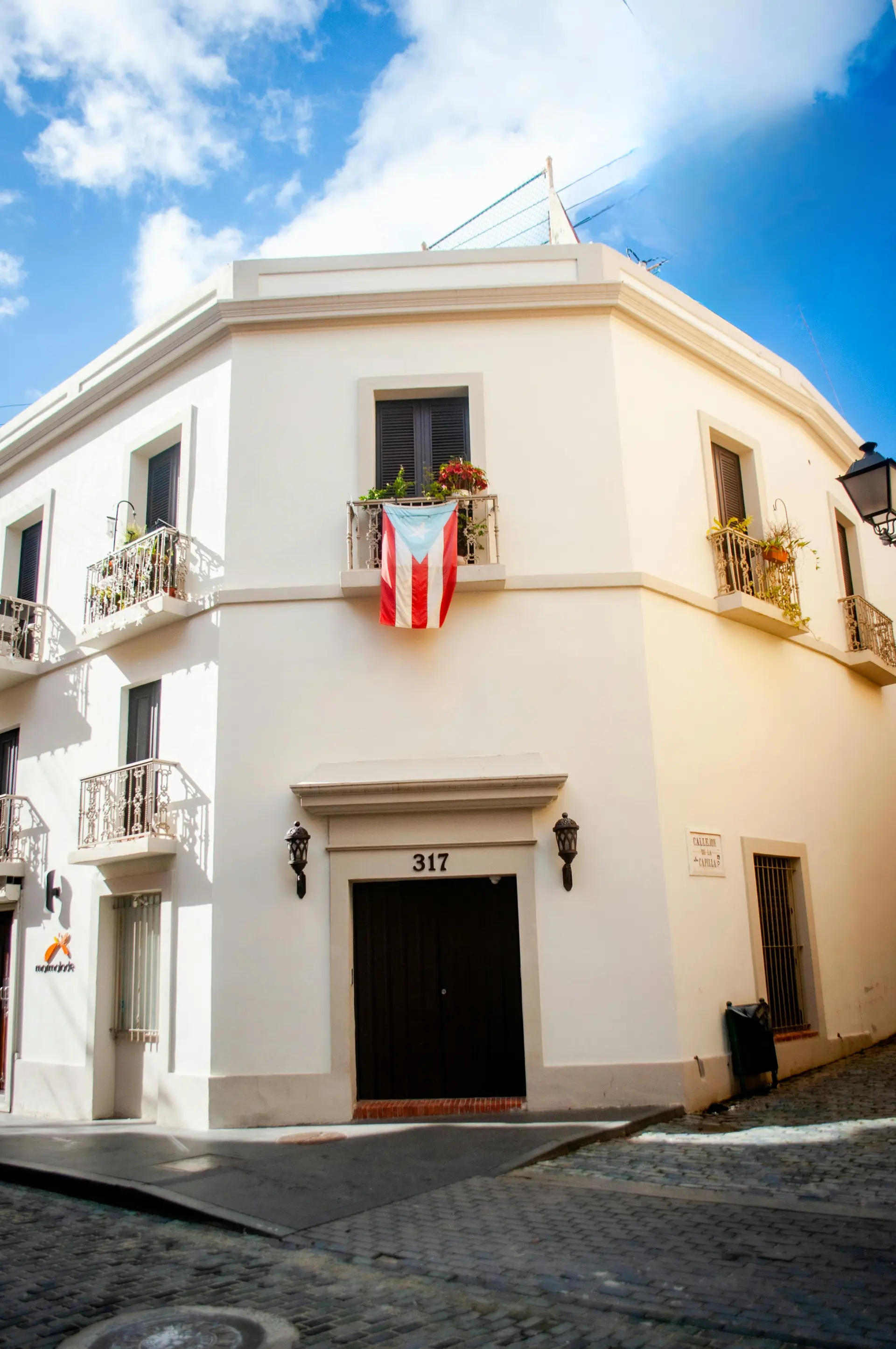 Edificio residencial de estilo colonial en Puerto Rico con la bandera puertorriqueña